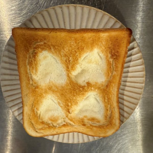 焼きあがった食パンに白いハート型のくぼみが４つできている様子