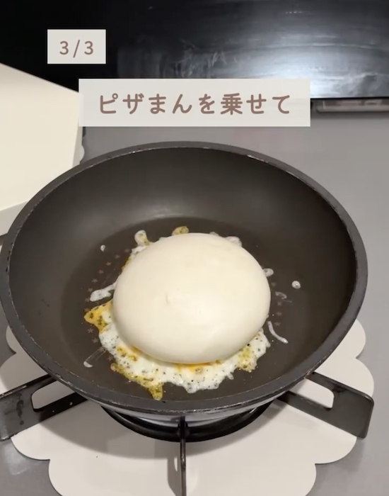 フライパンのチーズの上にピザまんをのせる様子
