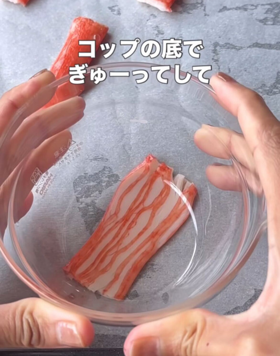 コップの底でカニカマをつぶしている様子