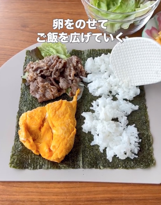 具材がのった海苔の上にごはんをのせる様子