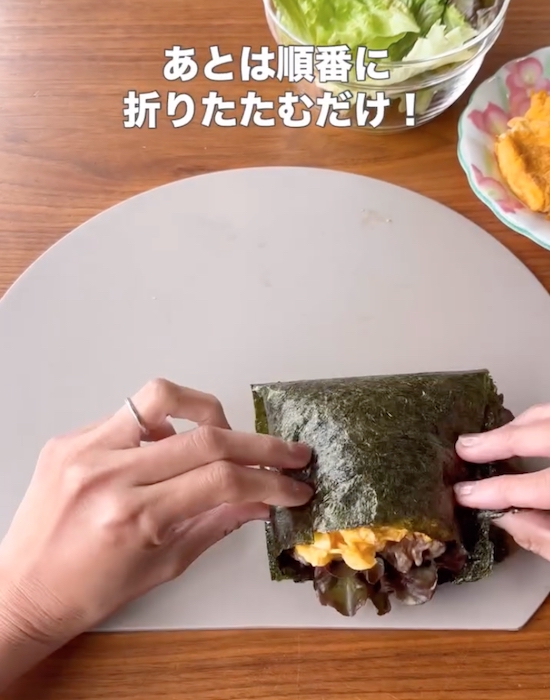 具材とごはんを海苔で包む様子