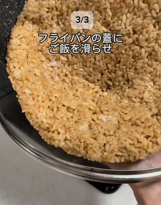 ご飯をフライパンの蓋にスライドしている様子