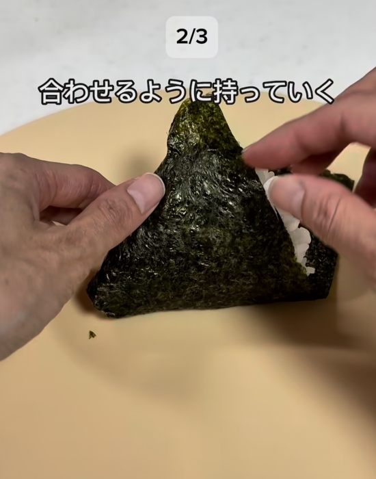 おにぎりの海苔を折っている様子