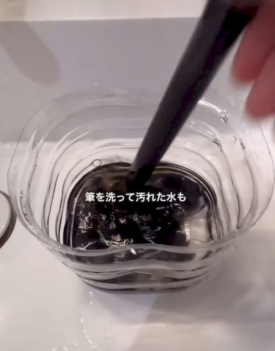 ペットボトルで筆を洗っている様子