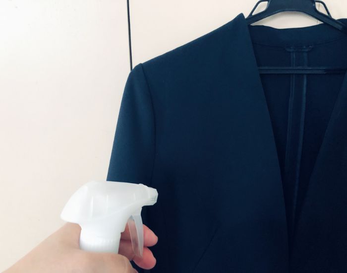 スーツにスプレーを吹きかける様子