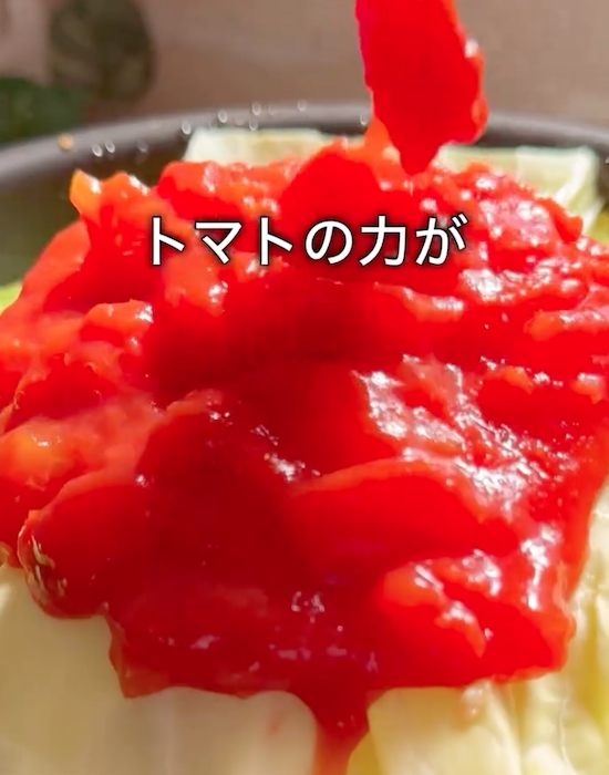 キャベツの上にトマト缶を入れる様子