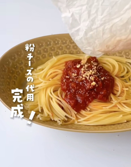 パスタに粉チーズをかけている様子