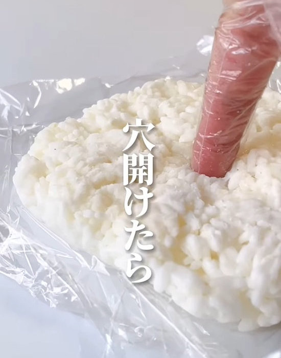 ラップにのせたごはんに指で穴を開ける様子