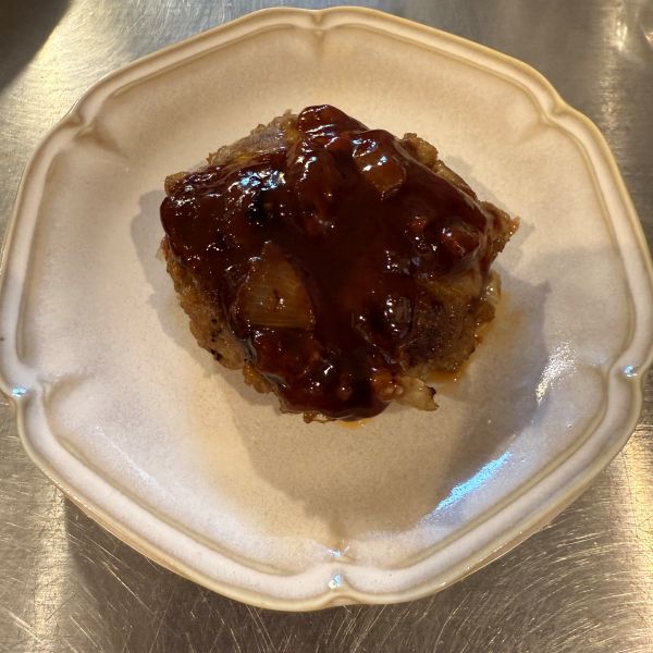 皿にのせたハンバーグにソースをかけた様子