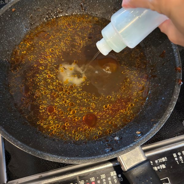 使い終えたフライパンに食器用洗剤を入れる様子