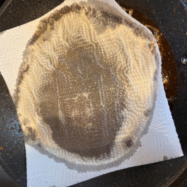水と食器用洗剤を入れたフライパンの中にキッチンペーパーを入れた様子