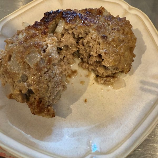焼けたハンバーグを皿にのせて半分に割った様子
