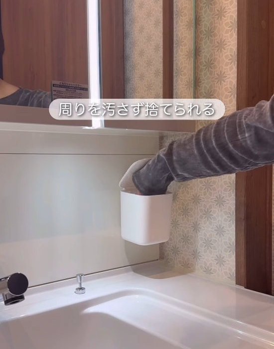 壁面に設置したダストボックスにゴミを捨てる様子