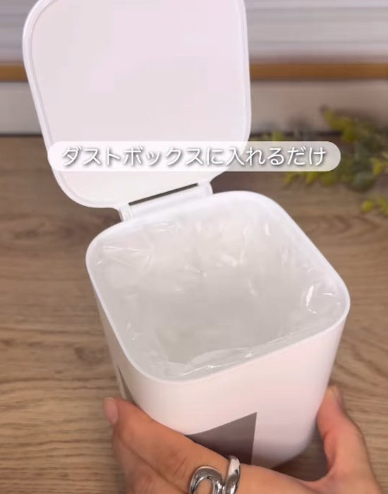 くつした整理カップを入れたダストボックスを手にしている様子