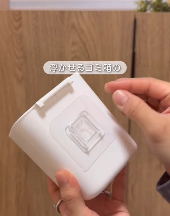 ダストボックスの裏側にブラシ用ホルダーのフィルムを貼り付ける様子