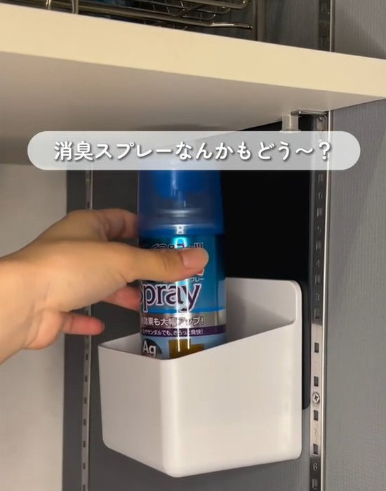 ブックエンドに付けたホルダーに消臭剤を収納する様子