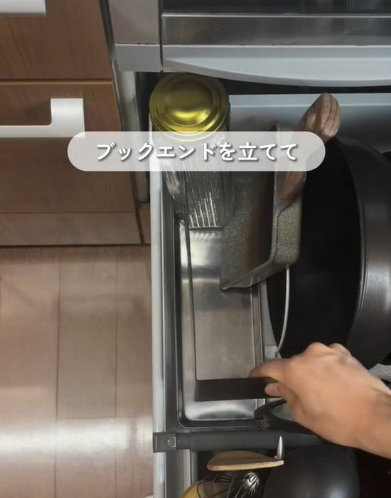 キッチン下の収納にブックエンドを設置する様子