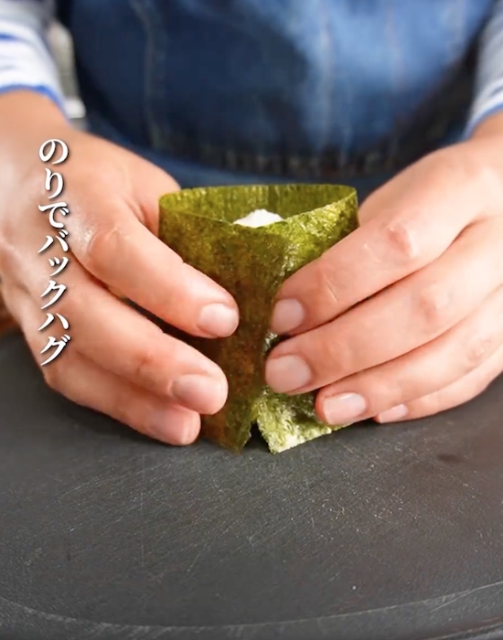 おにぎりに海苔を巻き付ける様子