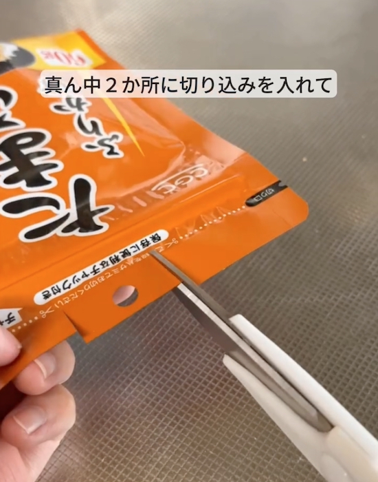 ふりかけの袋に切り込みを入れる様子