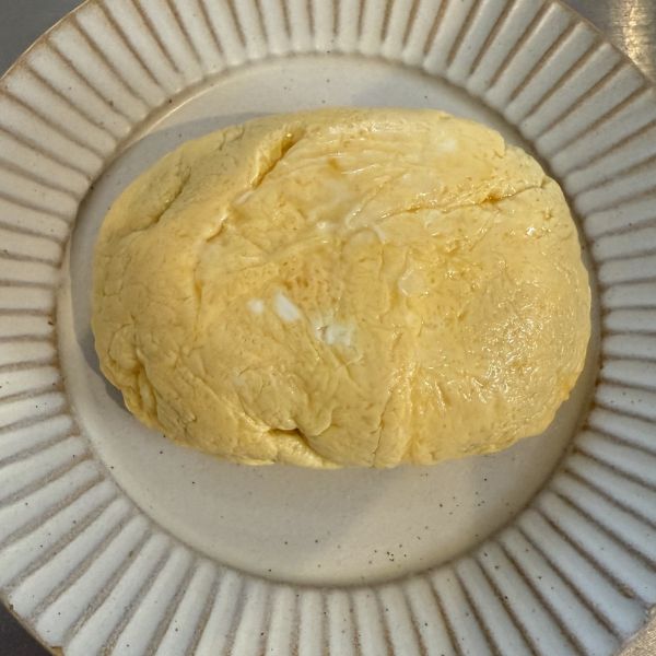 ラップで形を整えたオムレツを皿に出した様子