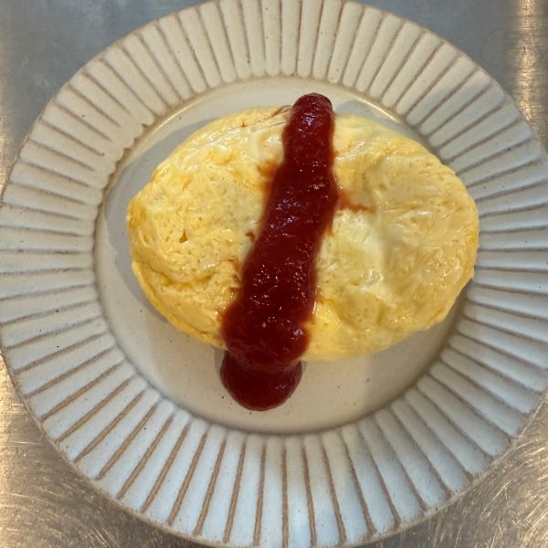 完成したオムレツにケチャップをかけた様子