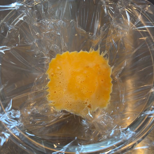 ラップを敷いた耐熱容器に卵液を流し入れた様子