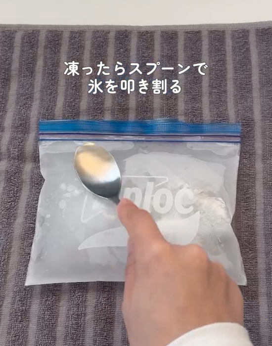 ビニール袋の上からスプーンで氷を割る様子