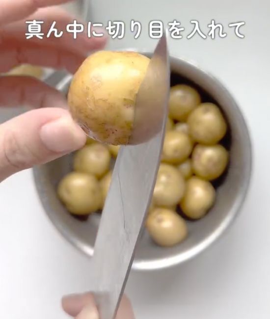ジャガイモの中央に包丁を当てる様子
