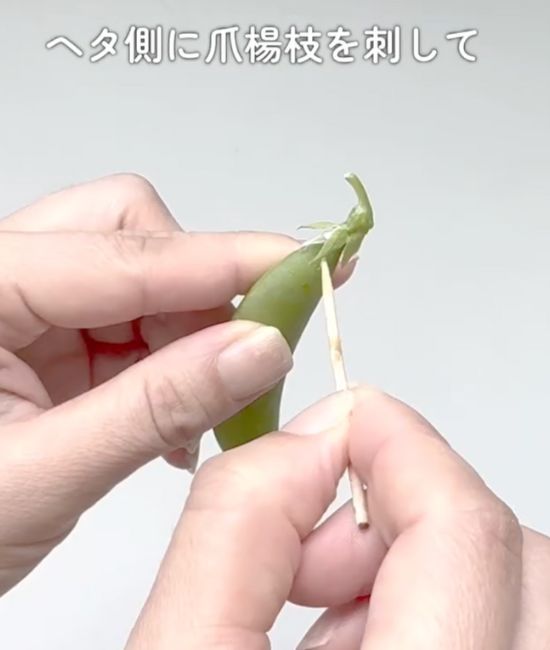 スナップエンドウのヘタにつまようじを刺す様子