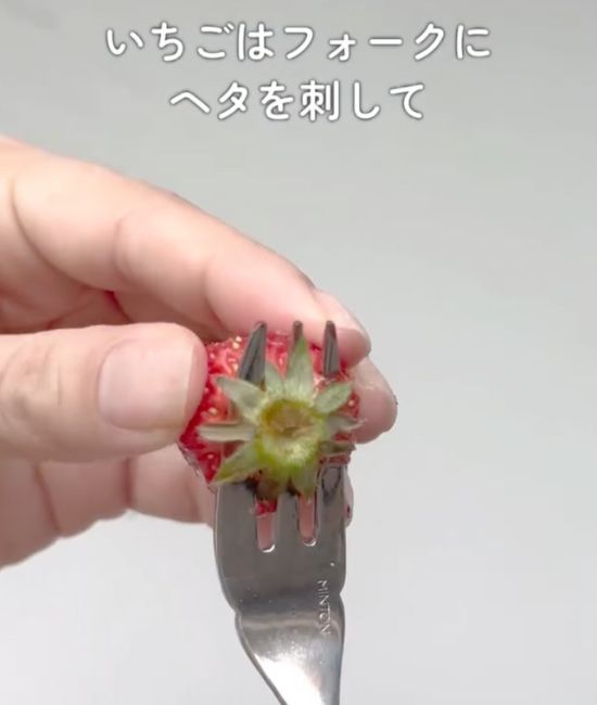フォークをイチゴのヘタのすぐ下に刺した様子