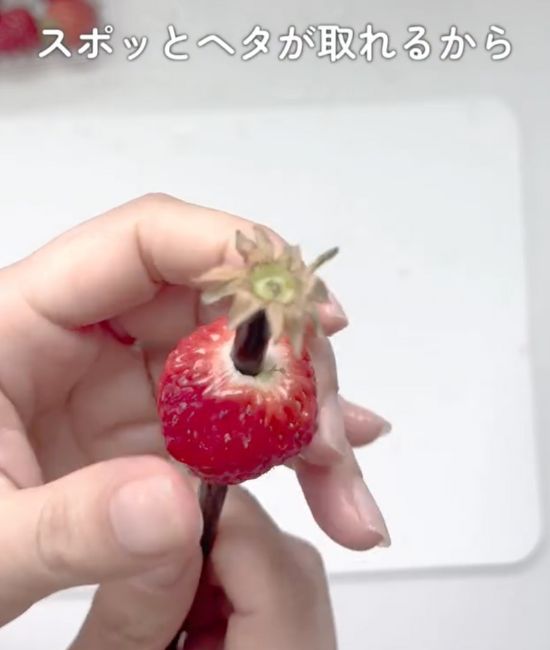 イチゴの尖った部分にストローを刺した状態でヘタのほうまで貫通させた様子