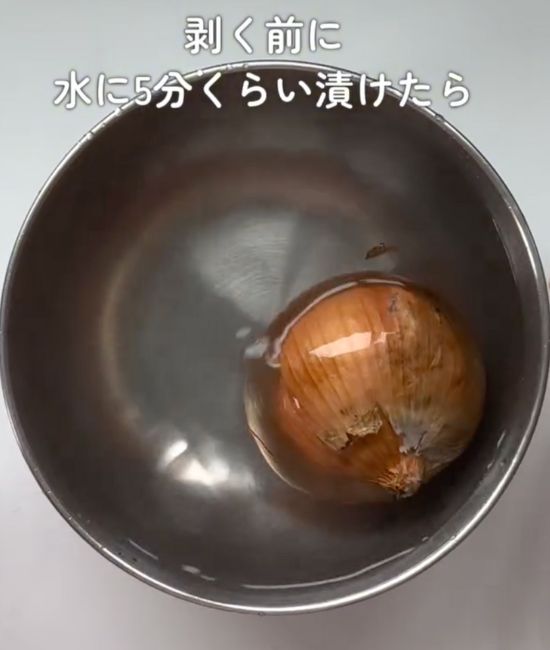 水を張ったボウルに皮の付いた状態のタマネギを入れた様子