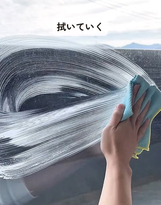 窓をクロスで掃除する様子