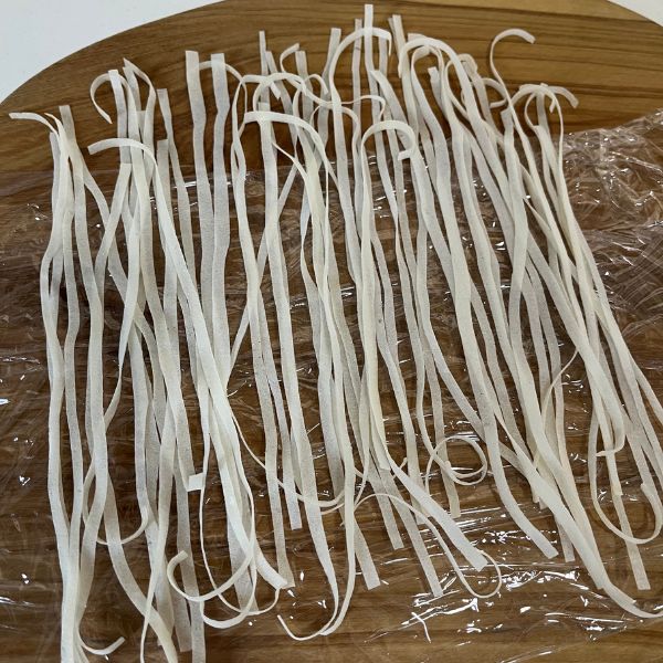 ラップの上に細切りにした春巻きの皮を広げた様子