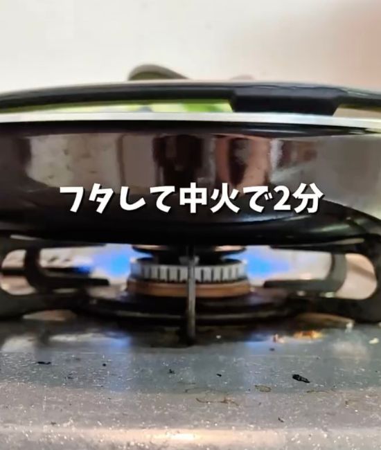 蓋をしたフライパンを火にかける様子