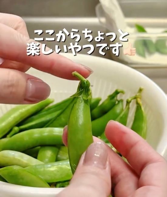 スナップエンドウのヘタの部分を指さす様子