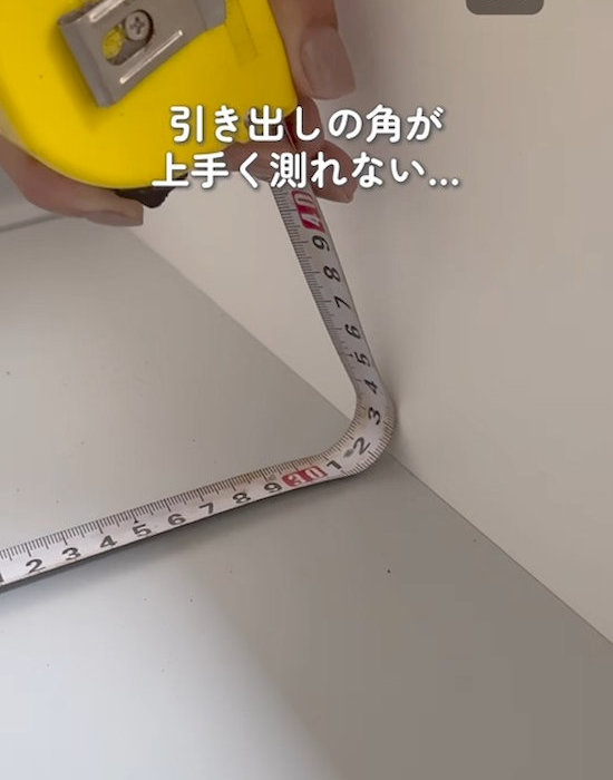メジャーを引き出しの角に当てる様子