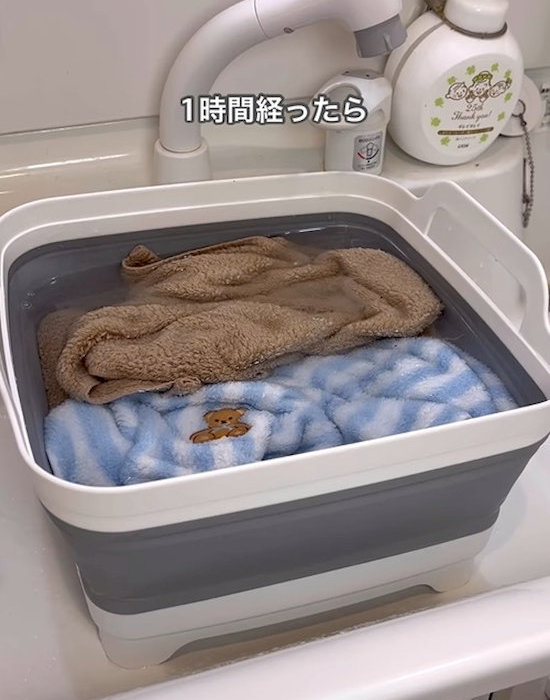 たらいの中にタオルを浸け込む様子