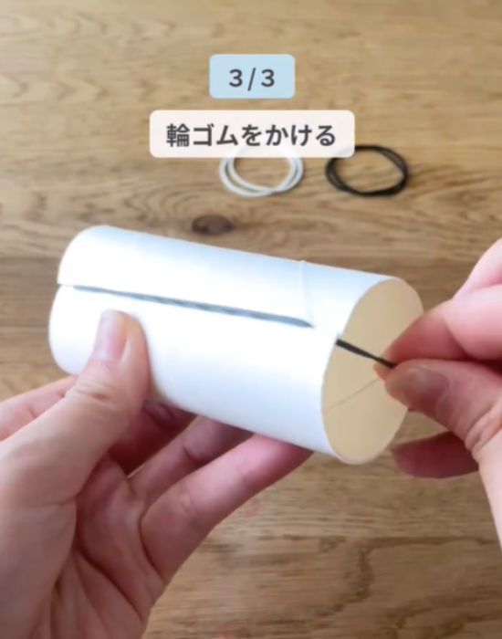 カットしたトイレットペーパーの芯に輪ゴムをかけている様子