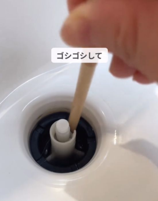 ストローを排水口の中に入れてこすっている画像