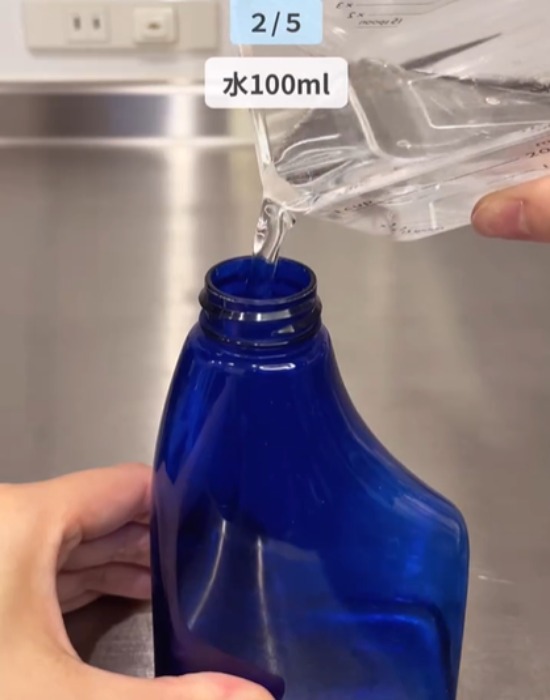 スプレーボトルに水を入れている様子