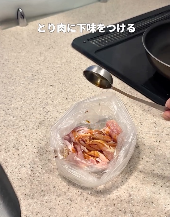 ビニール袋に入った鶏肉に味付けする様子