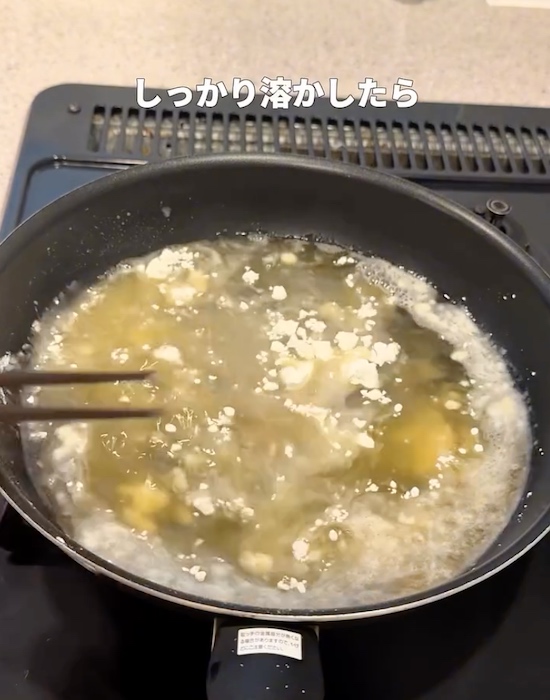 フライパンで熱した油に小麦粉を入れる様子