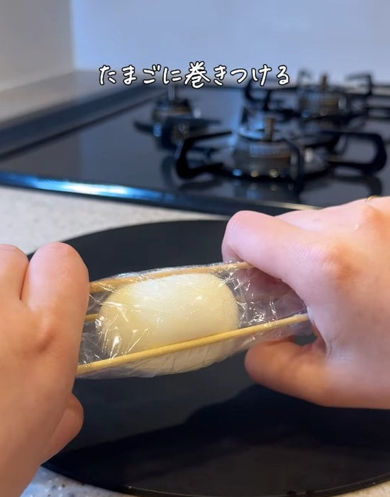竹串とラップでゆで卵を固定している様子