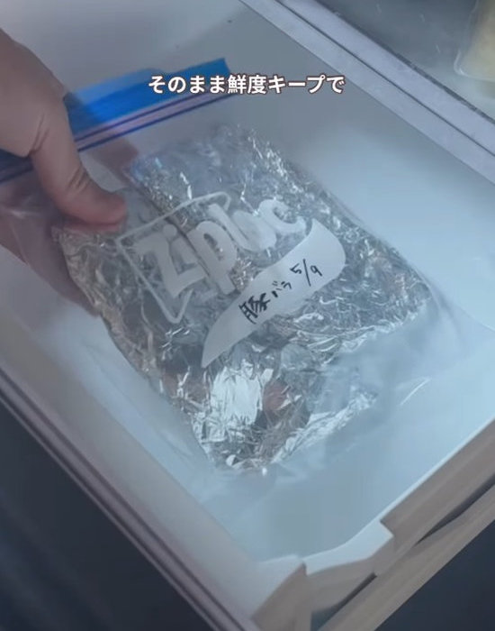 フリーザーバッグに入った肉を冷凍庫に入れる様子