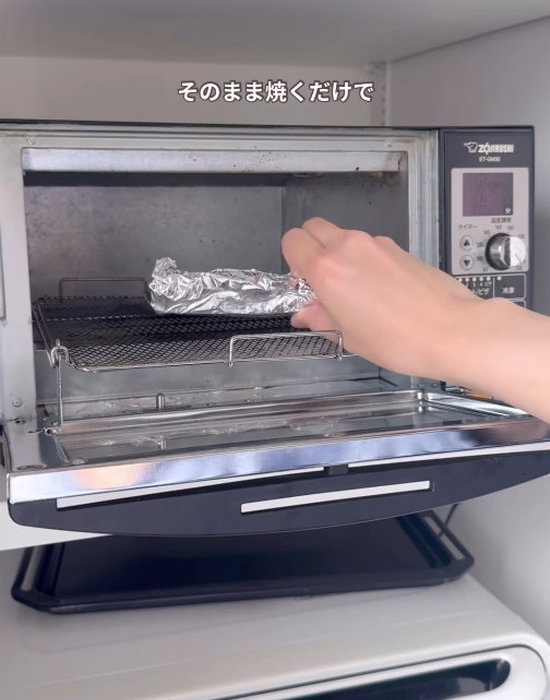 アルミホイルで包んだ食パンをトースターに入れる様子