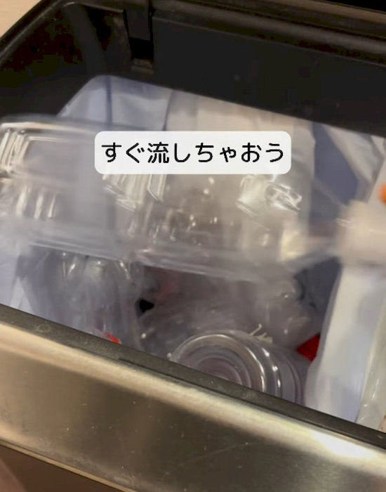 空のペットボトルをゴミ箱に入れる様子