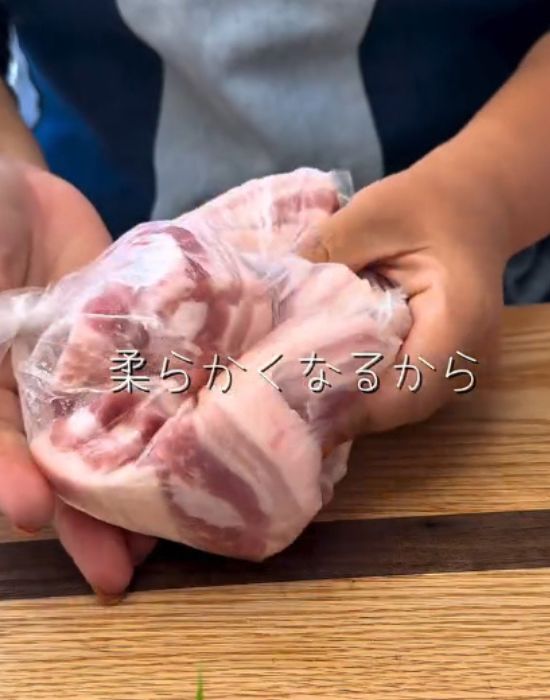 ポリ袋に入れた豚バラ肉と塩こうじを馴染ませるように袋の上から揉む様子