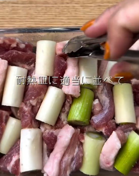 豚バラ肉の上に切ったネギをのせる様子