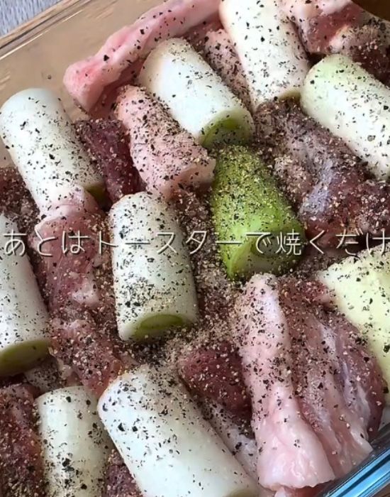 耐熱容器に入れた豚バラ肉とネギにコショウをかけた様子